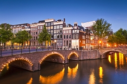 Charming Amsterdam canal bridge lighted at the corner of Keiszergracht, one of the three original canals created within the ring of canals